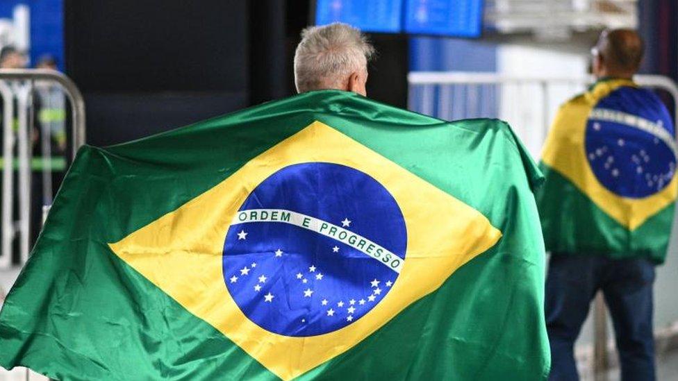 Supporters of former Brazilian president Bolsonaro await his arrival at the international airport in Brasilia, Brazil, 30 March 2023.