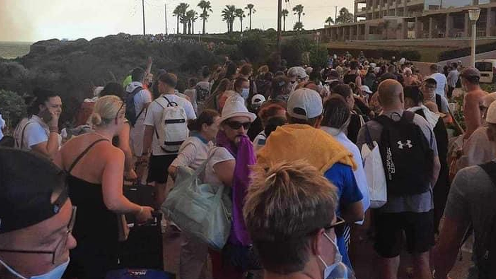 People on the beach during fires in Rhodes