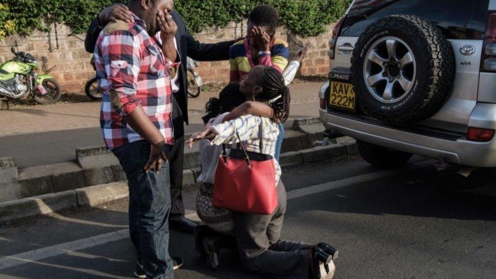 A woman (center lower left) evacuated from DusitD2 compound in Nairobi after a blast followed by a gun battle is reunited with her family on January 15, 2019.