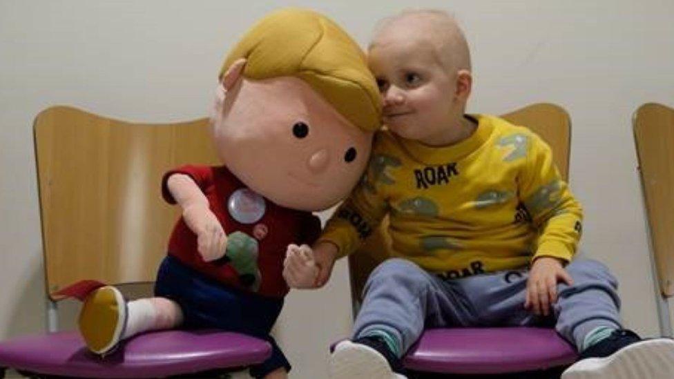 Ralph Tatham, 3, sitting with his doll