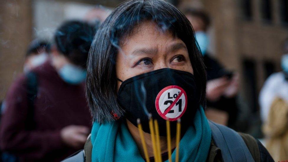 May Chiu lights incense during a vigil following a demonstration against anti-Asian racism in Montreal, Quebec, Canada, on March 21, 2021.