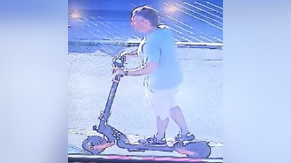 CCTV image of man on black and orange scooter