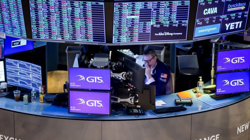 A sole trader surrounded by screens on the floor of the New York Stock Exchange