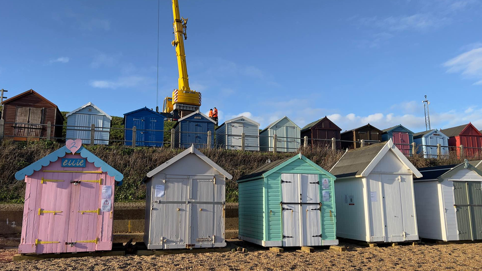 A crane lifting up one of the beach huts at Felixstowe beach