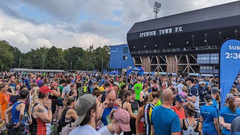 A large crowd of runners gathered together outside Ipswich Town's Portman Road football stadium