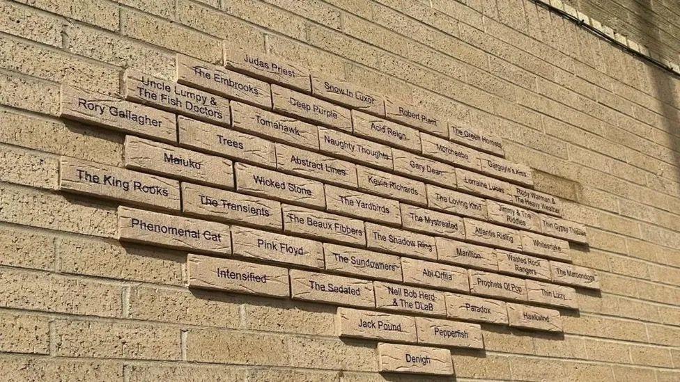 A display of musicians names on a wall.