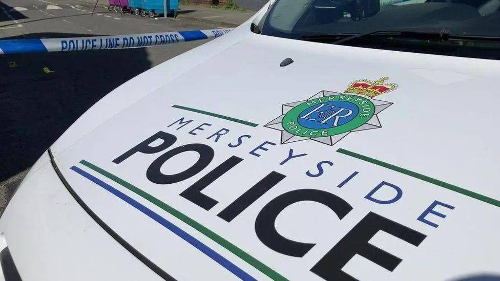 A close up of the front of a Merseyside Police vehicle with the force's badge and the words 'Merseyside Police' displayed prominently on the bonnet