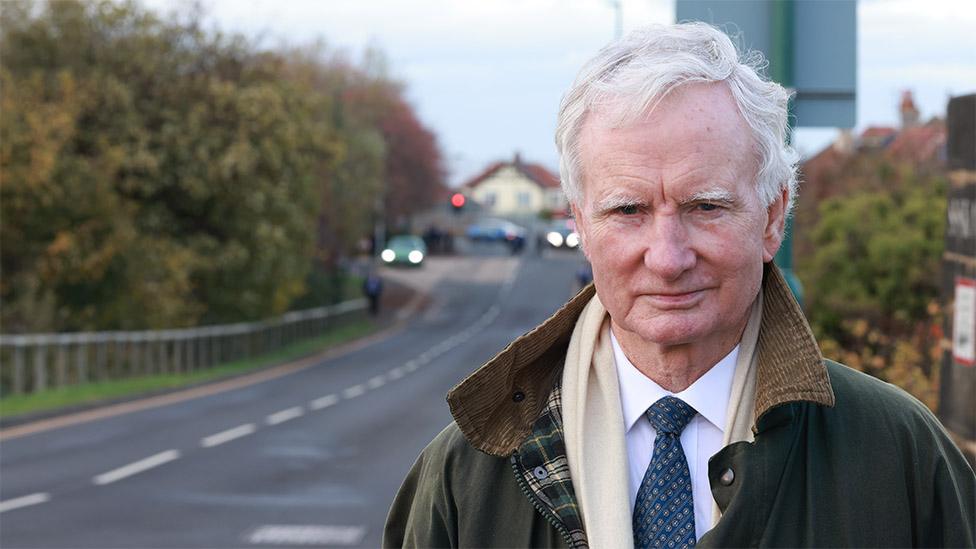 Saltburn councillor Philip Thomson standing in front of a road