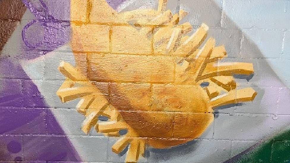 a section of the mural depicting a takeaway of fish and chips