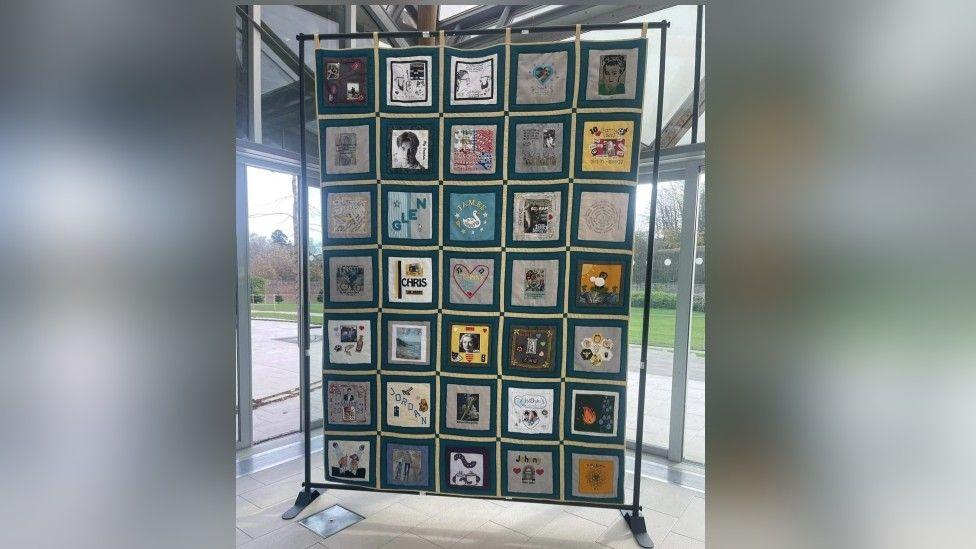 The memorial quilt is made up of 37 panels, five across and seven down. They each show a difterent image - some have the of a person, others are just symbols 