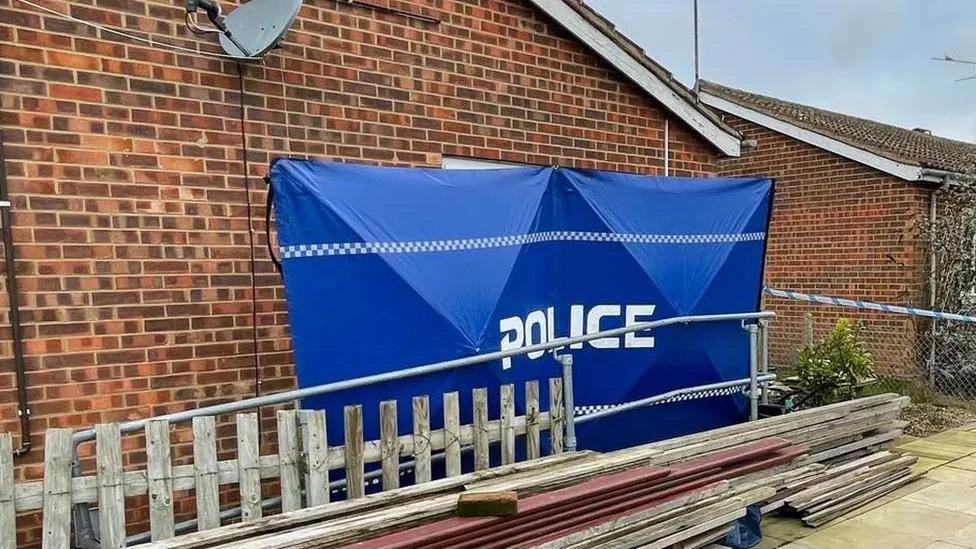 A blue tent with word police written on outside a house