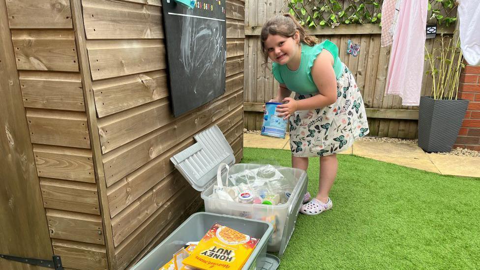 Marnie Rae putting recycling in tubs