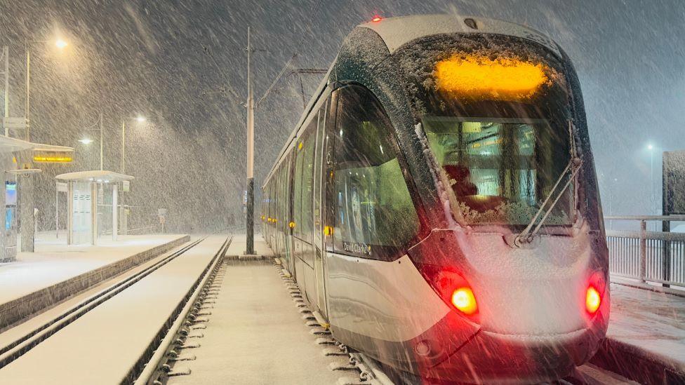 Snow falls at a tram station in Hucknall, Nottinghamshire