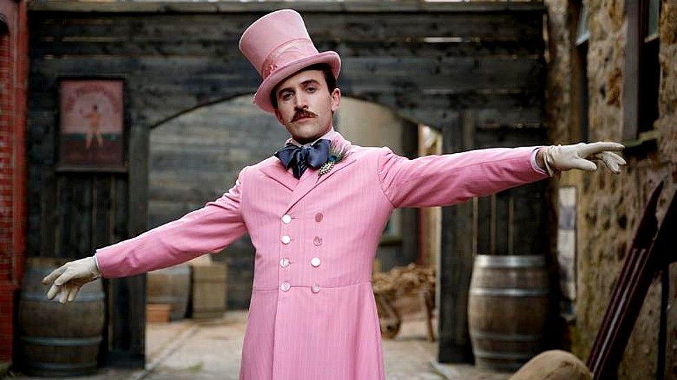 Actor Callum Scott Howells dressed in a pink frock coat and top hat, portraying Henry Paget, 5th Marquess of Anglesey in the film Madfabulous