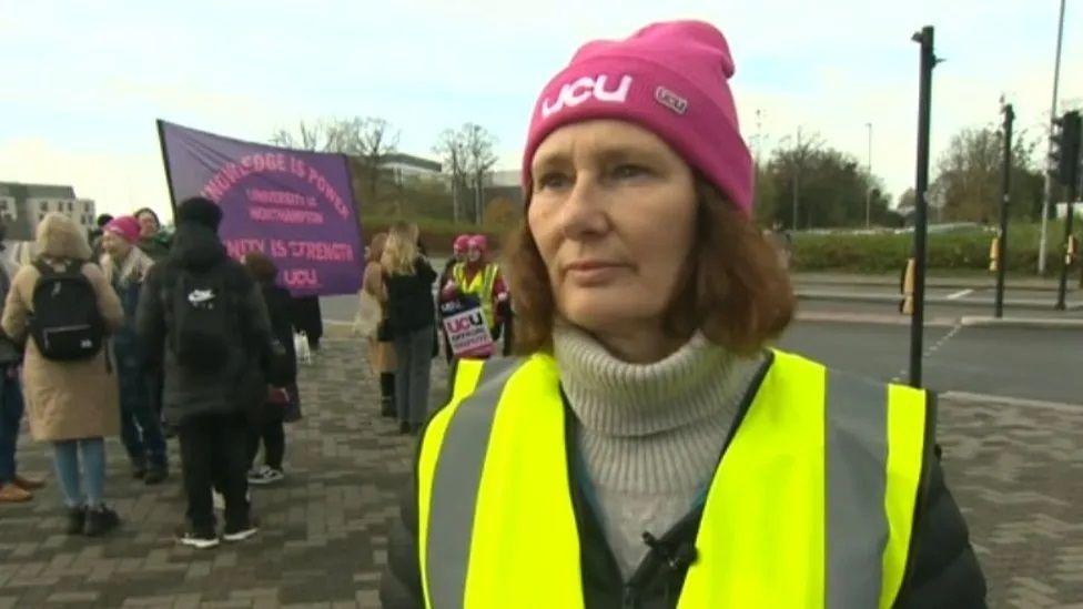 Sonya Andermahr with long dark hair, wearing yellow hi-vis and pink UCU hat