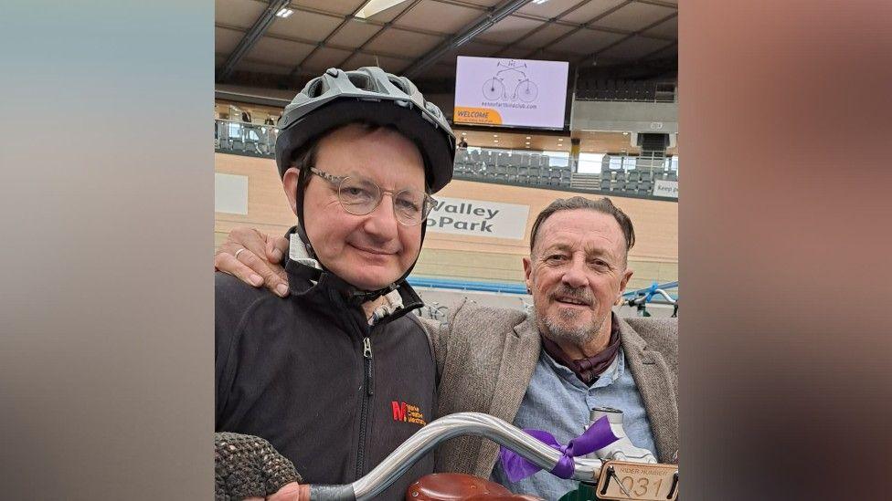 Two men taking a selfie in a velodrome