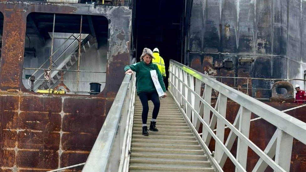 A female volunteer is carrying meet off the gang plank of the Stena Immaculate vessel in Great Yarmouth.