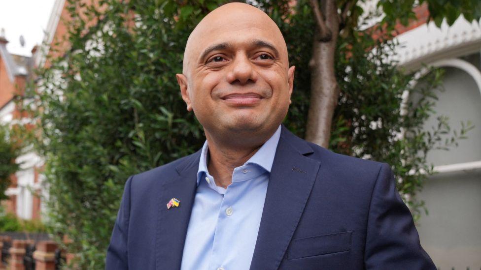 Sajid Javid pictured leaving his home in London, July 6, 2022, seen with trees and houses in the background