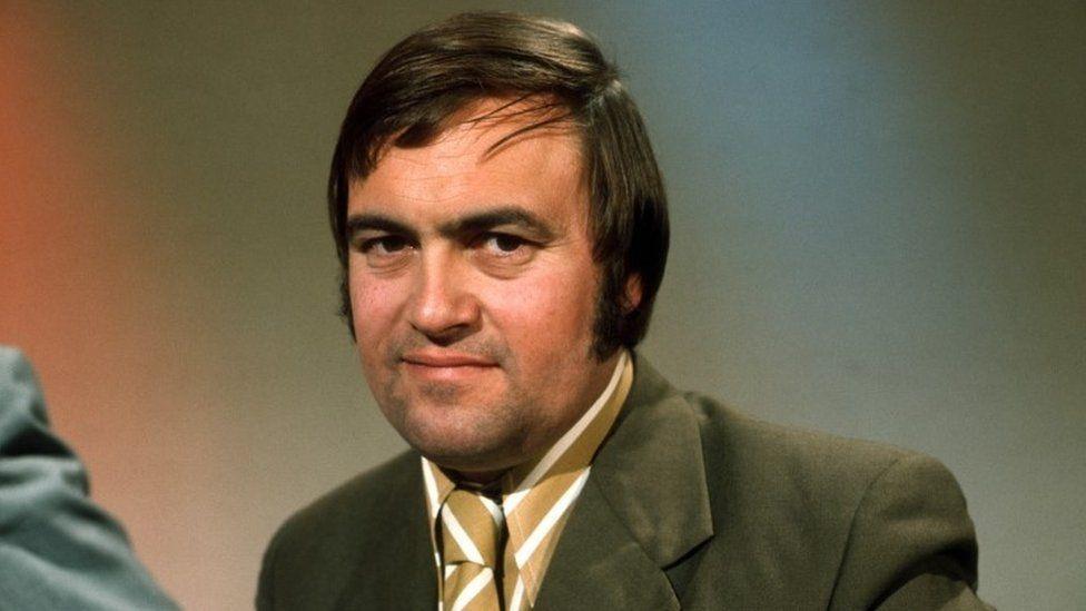 John Prescott in 1970 wearing a brown suit and yellow and white striped tie and shirt