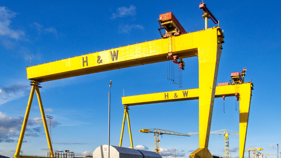 Harland and Wolff yellow cranes against a blue sky line, one crane is close and one is far away. 