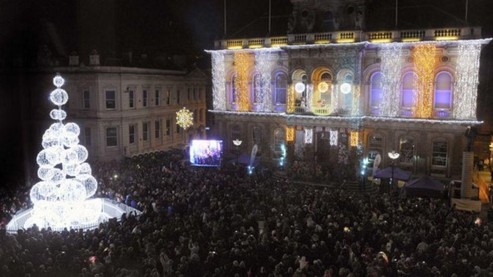 A picture taken from above Ipswich town centre at Cornhill. Hundreds of people are pictured gathered outside the town hall and around the bauble Christmas tree. The town hall is lit up in Christmas lights.