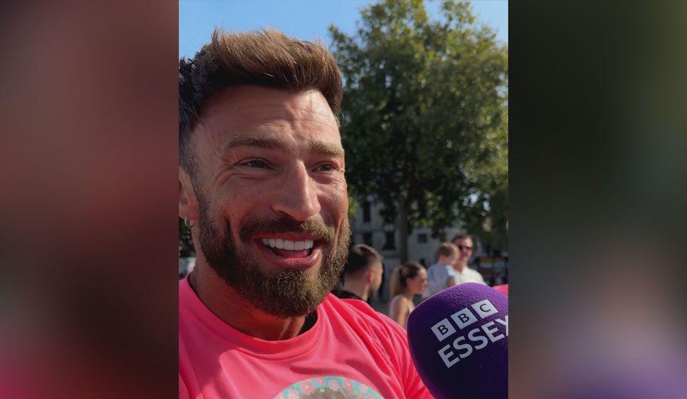 Jake Quickenden wearing pink T-shirt and being interviewed by BBC Essex