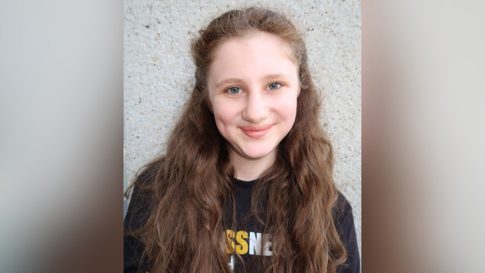 A head shot of Mary-Kate. She is smiling at the camera. She has long light brown hair.
