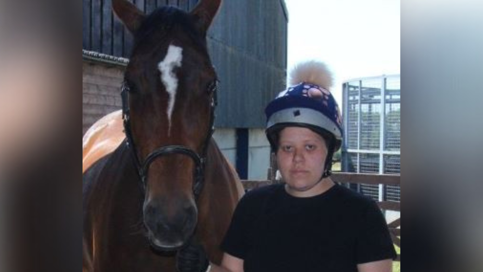 Storm Rogers-Davies pictured next to a brown horse.