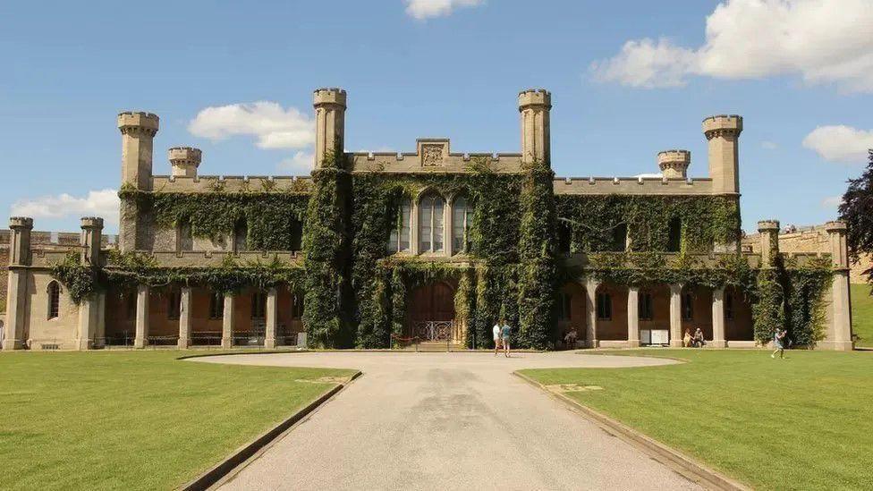 A two-storey Victorian Gothic crown court building with stone pillars, a crenelated roof and six towers with ivy growing up its walls.