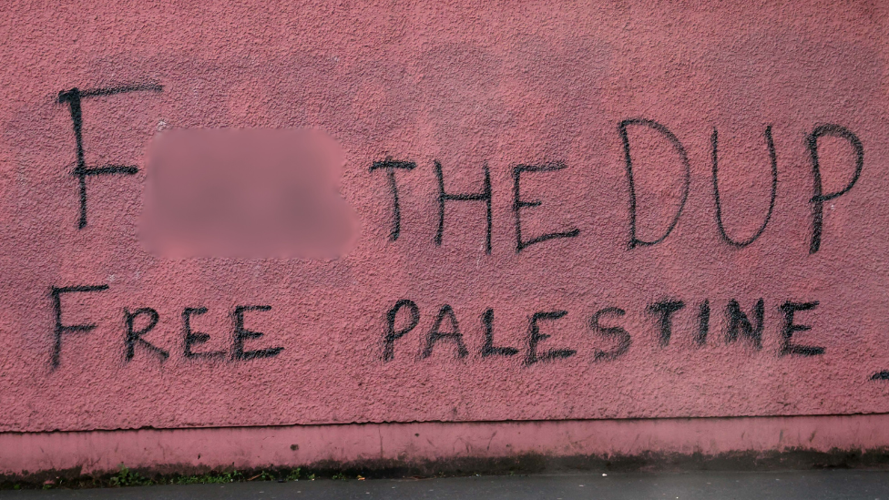 Graffiti on red wall, reas "F the DUP, Free Palestine!