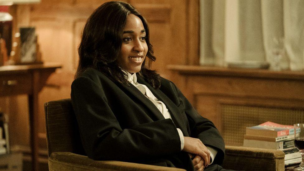 Ayo Edebiri in After The Hunt, sitting in a chair wearing a suit