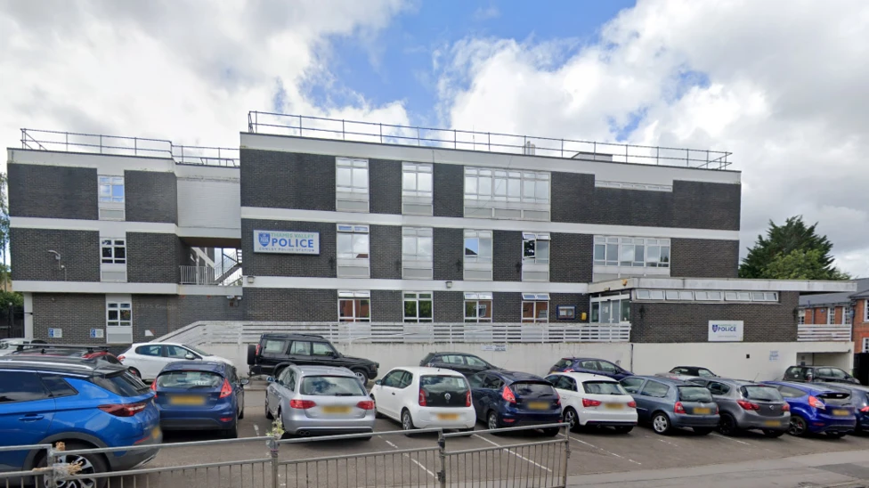 A Google Maps picture of Cowley police station, a three storey office building with about 20 cars parked outside it.