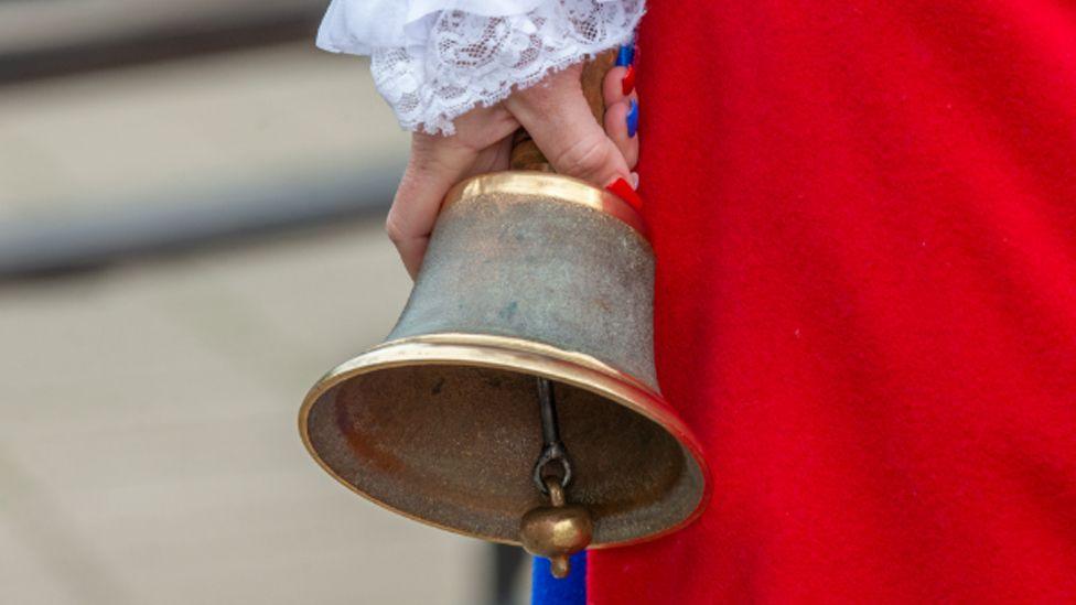 A close up of the handbell being held by Kila Redfearn