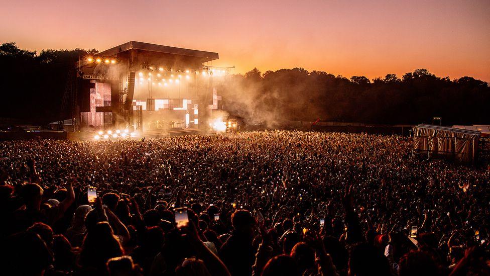 The stage at Parklife, brightly light, and thousands of people holding their mobile phones up to take a picture 