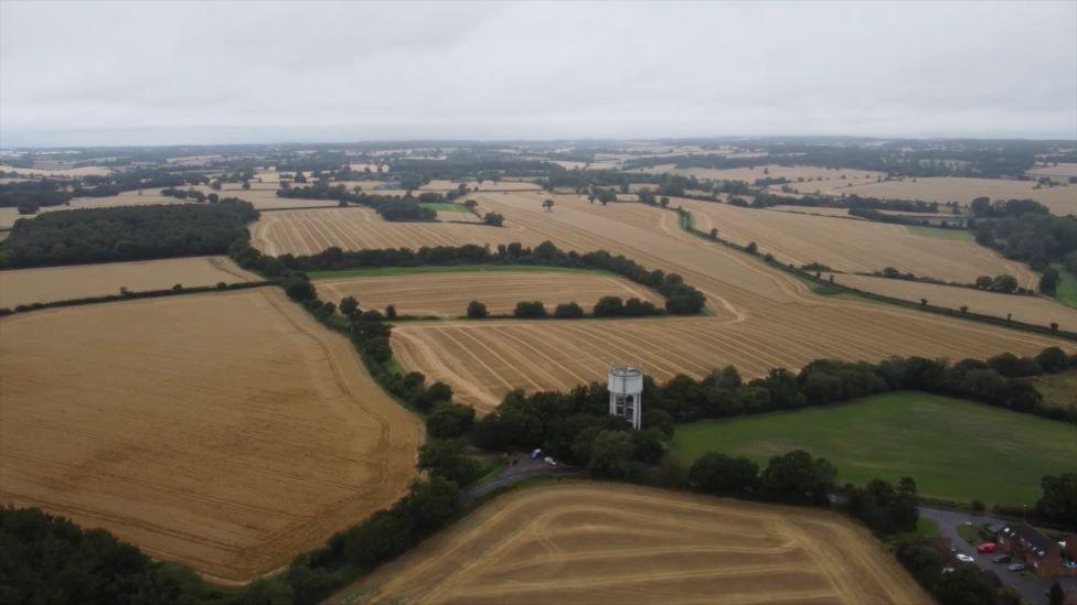 Aerial shot of brown and green fields in Hertfordshire.