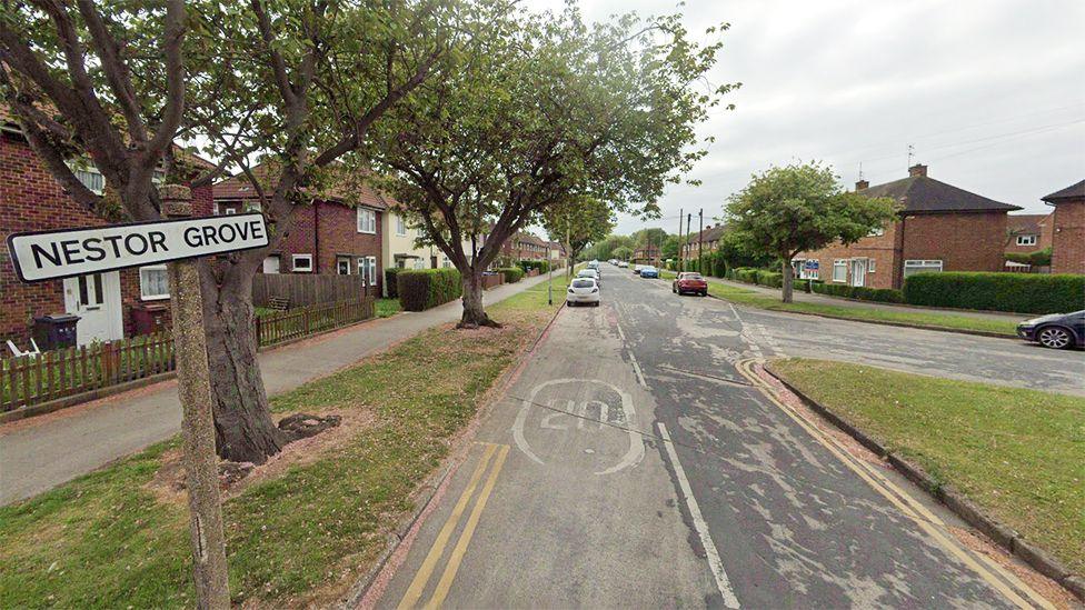 View of Nestor Grove in Hull showing the street sign and houses fronted by pavements and grass verges