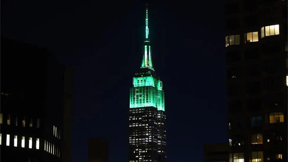 Empire State Building in New York is lit up green.