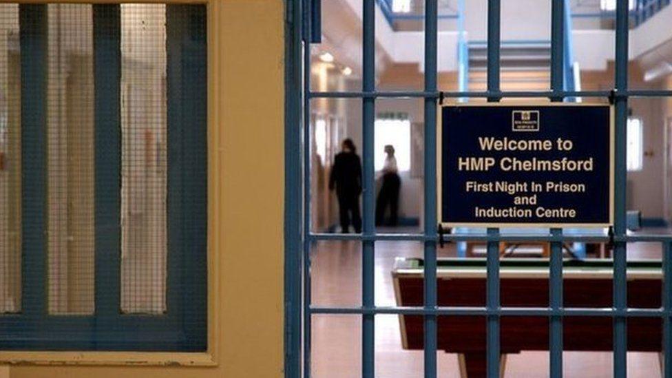 A gate inside HMP Chelmsford. Behind it is cells and a pool table.