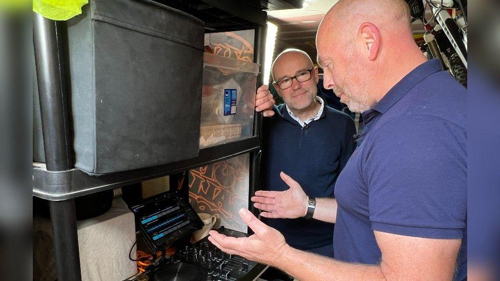 Jim Newman shows his mixes in his garage to Chris Baxter