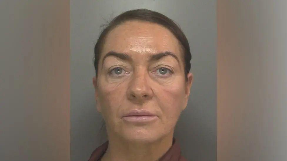 A police custody photograph of Natalie Bennett who has dark brown hair tied back and blue eyes.