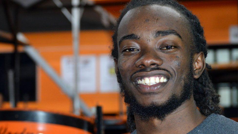 Shaquille Gaskin smiles at the camera while posing for a picture