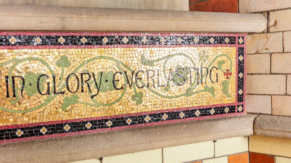 Church of St Anne, St Anne's Drive, Haughton, Denton, Greater Manchester.   Interior, detail of mosaic tiles on wall to the north west of the font