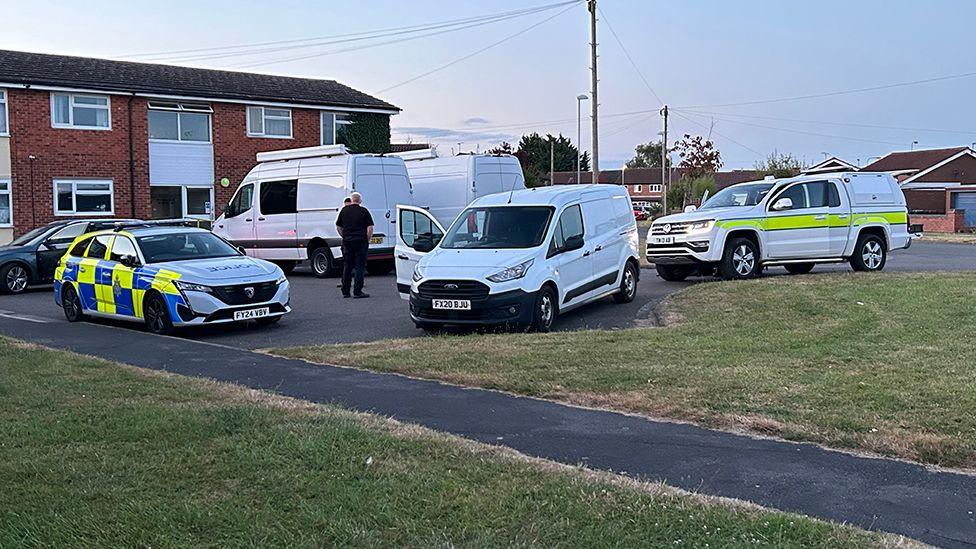 A number of emergency services vans parked outside the house in Lincoln