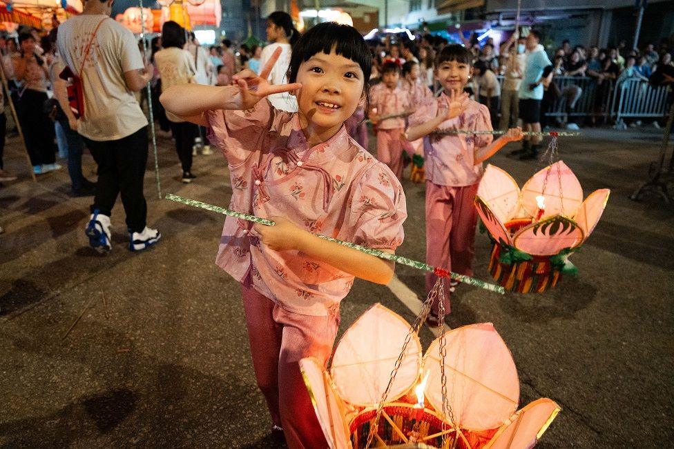 Girls carrying lanterns during festival. 