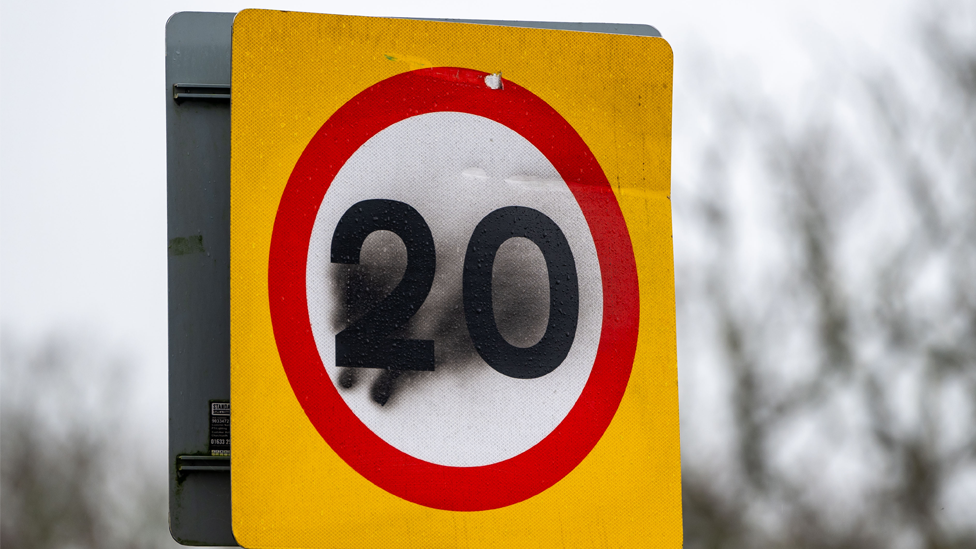 A 20mph road sign with black graffiti over the number 20