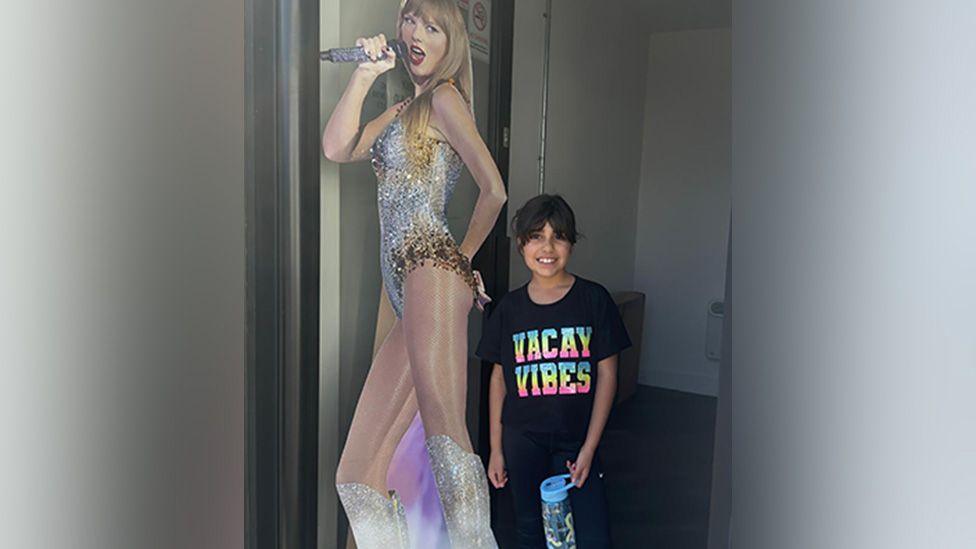 Alice da Silva Aguiar poses next to a cardboard cut-out of Taylor Swift