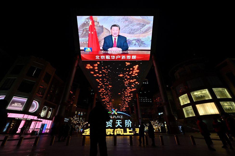 A large screen shows Chinese President Xi Jinping delivering a speech ahead of the New Year's eve celebrations in Beijing on December 31,