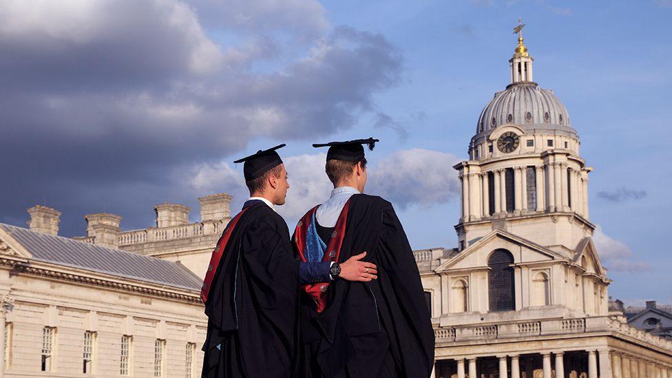 Male students at the University of Greenwich posing for pictures on graduation day in the grounds of the Old Royal Naval College in London.