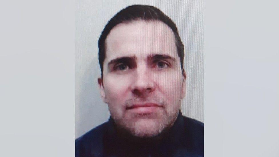 Police image of Steven Stewart who is wearing a dark top and has dark hair.