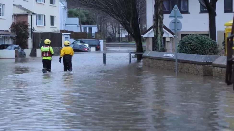 Rescuers wade through flood water